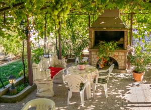 eine Terrasse mit einem Tisch, Stühlen und einem Kamin in der Unterkunft Gina in Rijeka