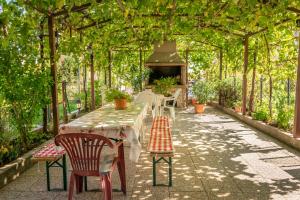 eine Terrasse mit Tisch und Stühlen unter einer Pergola in der Unterkunft Gina in Rijeka
