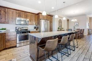 a kitchen with wooden cabinets and a large island with bar stools at Red Rock Ranch Retreat: Paradise Village #10 in Santa Clara