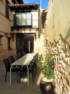 stół i krzesła na patio z kamienną ścianą w obiekcie Casa rural El Rincón de las Estrellas w mieście Sigüenza