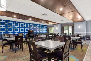 una sala da pranzo con tavoli, sedie e pareti blu di SureStay Plus Hotel By Best Western Portland Route 52 West a Portland