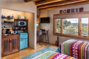 a bedroom with a bed and a kitchen and a window at Bobcat Inn in Santa Fe