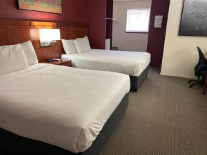 a hotel room with two beds and a desk at Lakeshore Inn Water Front in Moses Lake