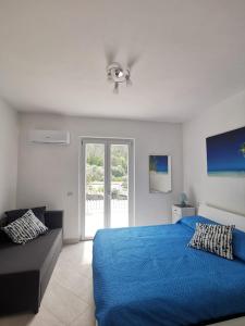 a bedroom with a blue bed and a couch at SANTACROCE&S.ANTONINO HOUSE in Termini