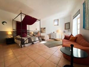 salon z łóżkiem i kanapą w obiekcie Orangerie de Cardet - Maison d'hôtes - B&B w mieście Cardet