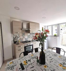 a kitchen with a table with a vase of flowers on it at SANTACROCE&S.ANTONINO HOUSE in Termini +37 photos