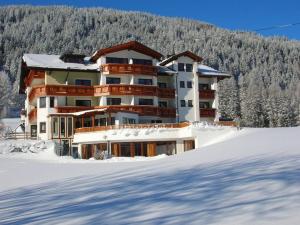 a large building in the snow in front of a mountain at Hotel Humlerhof in Gries am Brenner