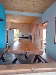 una gran mesa de madera en una habitación con cocina en casa bela vista, en Milho Verde