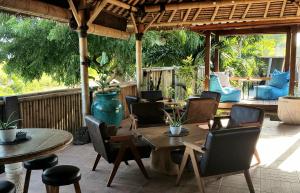 un patio al aire libre con mesas, sillas y una mesa en Ombak Resort at Ekas , a luxury surf and kite surf destination, en Ekas