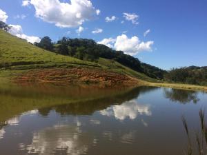 a view of a river with clouds in the sky at Pousada Rural e Pesqueiro Chalé da serra in Conceição da Ibitipoca