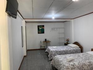 a room with two beds and a flat screen tv at Globi lodge #2 in Monteverde Costa Rica