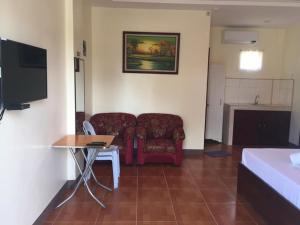 a room with a couch and a table and a chair at ALTHEA BIRDS NEST INN in Moalboal