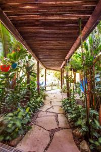 une passerelle couverte dans un jardin avec des plantes dans l'établissement Pousada Refúgio de Maresias, à Maresias