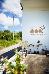 a white building with plants on the side of it at Shimaotoya in Iriomote