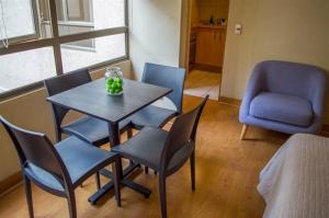 sala de estar con mesa, sillas y silla en UH Departamento Amoblado Lastarria, en Santiago