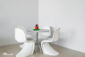 a white table and chairs against a white wall at Shanzo Ansen Homestay in Taitung City