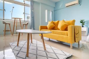 ein Wohnzimmer mit einem gelben Sofa und einem Tisch in der Unterkunft Shanzo Ansen Homestay in Taitung