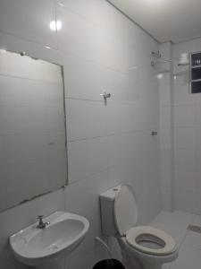 a white bathroom with a toilet and a sink at Hotel Santos in Santos