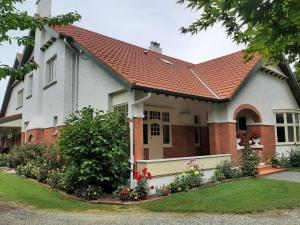 una casa con techo rojo en Wainono Homestead en Waimate