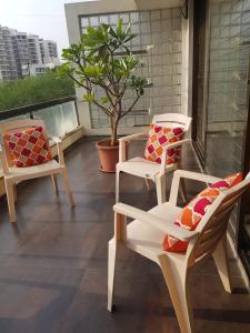 ナーシクにあるStatus Homeaway Service Apartmentsのバルコニー(椅子2脚、鉢植えの植物付)