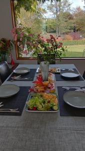 uma mesa com um prato de comida em Rose & Stream Retreat em Waikuku