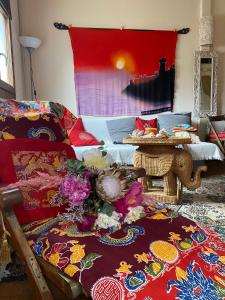uma sala de estar com um sofá e uma mesa com flores em La casetta dei Mosaici em Ilha Capraia
