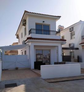 una gran casa blanca con una puerta azul en KapparisVilla, en Paralimni