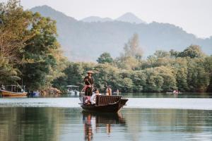 Ein Mann in einem kleinen Boot auf einem See. in der Unterkunft Aana Resort & Spa in Ko Chang
