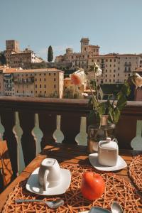 einen Tisch mit zwei Tassen und Tomaten auf einem Balkon in der Unterkunft Appartamenti Ponte Vecchio in Bassano del Grappa