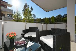balcone con tavolo e bicchiere di vino di Apartment Premium Wood Baltic Park - 58m2, 3 pokoje a Stegna