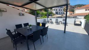 una mesa de comedor negra y sillas en un patio en Holiday house BEDEM, en Marina