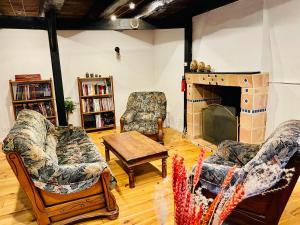 a living room with two chairs and a fireplace at Duguesclin entre Dinan et Plages in Corseul