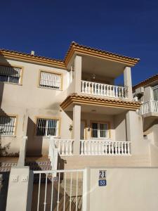 une grande maison blanche avec des balcons blancs dans l'établissement Magnifique maison entre mer et montagne, à Alicante