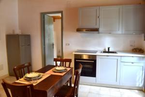 eine Küche mit einem Holztisch mit Stühlen und einem Waschbecken in der Unterkunft La Casa del cancello di Borgo Carbone in Locri