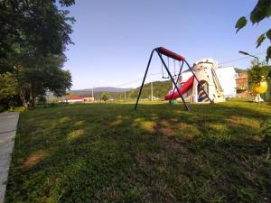 a park with a swing set in the grass at Holiday Home Racic in Bihać