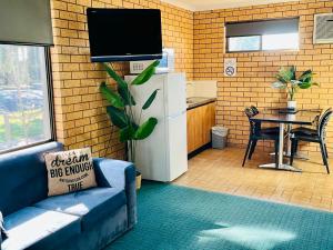 a living room with a couch and a refrigerator at Lake Mulwala Hotel in Mulwala