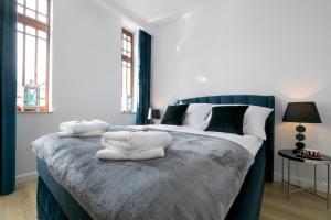 1 dormitorio con 1 cama grande y toallas. en Apartament Royal Blue Ustka en Ustka