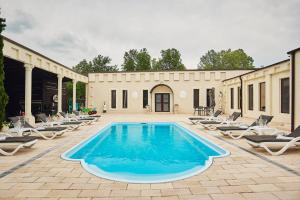 a swimming pool with lounge chairs and a building at La Conac Resort in Hulubeşti