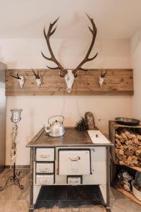 a kitchen with a table with antlers on the wall at Hotel Alpina in Galtür