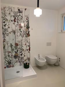 a bathroom with a flower wallpaper on the wall at Manciuno in Trento