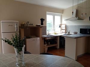 una cocina con un jarrón de flores sobre una mesa en Il Panorama Housing Cilento, en Santa Maria di Castellabate