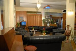 a living room with black leather couches and a television at Hotel Ismaele in Chiusi