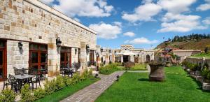 a building with a courtyard with a table and chairs at Seraphim Cave Suites & SPA in Urgup