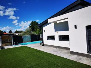 een wit huis met een zwembad en een tuin bij Luxory Minimal House 2. in Siófok