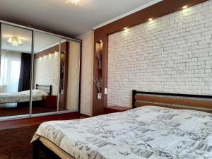 een slaapkamer met een bakstenen muur en een bed bij Староярмаркова с видом на парк и реку in Krivoy Rog