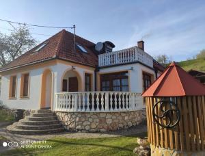 una piccola casa bianca con una recinzione davanti di Erzsébet Vendégház a Csesznek