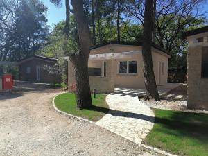 uma casa com duas árvores em frente a uma entrada em Holiday Park Mimoza em Basanija