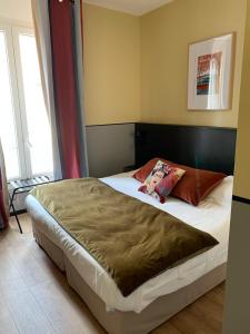a bedroom with a large bed with a brown blanket at Hôtel du Nord in Annecy