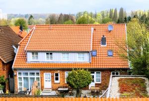 ein Haus mit orangefarbenem Dach in der Unterkunft Kalkberg Ferienwohnungen in Bad Segeberg