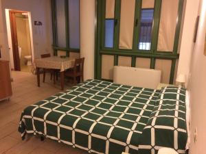 una camera con un letto verde e bianco e un tavolo di Studio for two people a Firenze